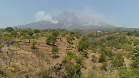 slopes volcano with forest fire, farmland at foot of the volcano Agung. tropical landscape aerial...