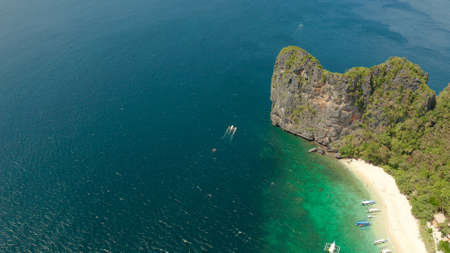 aerial view tropical beach on island with palm trees, blue lagoon and azure clear water. Helicopter...