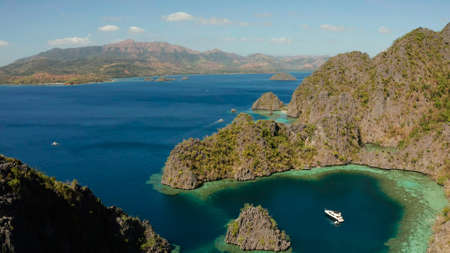 Aerial drone lagoons and coves with blue water among the rocks. lagoon, mountains covered with...