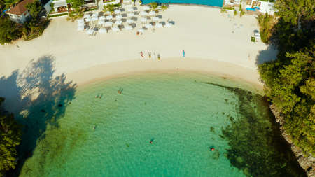 Cove with white beach in blue lagoon with turquoise waters, aerial view. Seascape with beach on...