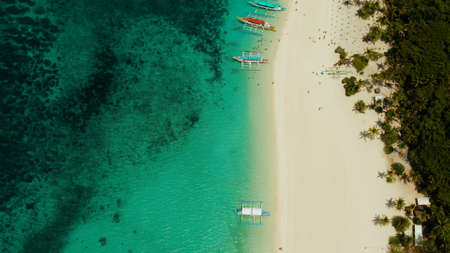 Aerial seascape: Tropical beach with palm trees and turquoise waters of the coral reef, from above, Puka shell beach. Boracay, Philippines. Seascape with beach on tropical island. Summer and travel vacation concept.の写真素材
