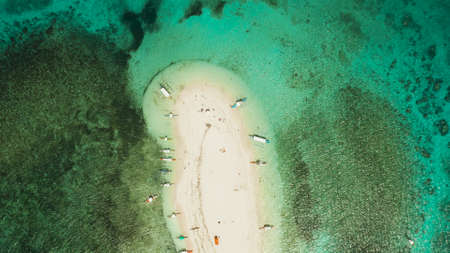 Sandy white island with beach and sandy bar in the turquoise atoll water, aerial drone.Tropical island and coral reef. Naked Island, Siargao.の写真素材