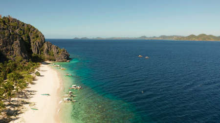 aerial drone tropical island and sand beach with palm trees. Malajon Island, Philippines, Palawan. tourist boats on coast tropical island. Summer and travel vacation concept. beach and blue clear sea waterの写真素材