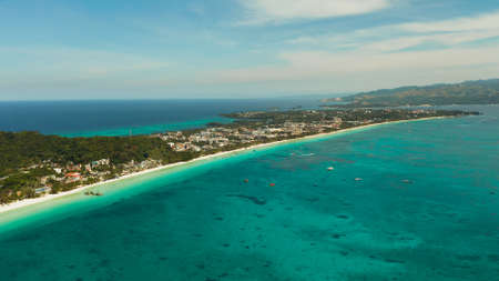 White sandy beach with turquoise water and tourists on Boracay Island, top view. Tropical white beach with sailing boat. Summer and travel vacation concept.の写真素材
