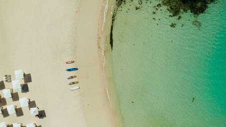 Tropical sandy beach with sun beds near the lagoon with turquoise water from above, Boracay,...