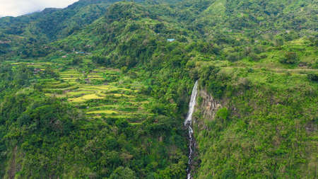 Mountain landscape with rainforest and waterfall, aerial view. Highlands with villages on the island of Luzon, Philippines.の写真素材