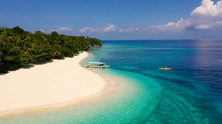 Seascape with a beautiful tropical island, aerial view. Mahaba Island, Philippines. Blue sea with...