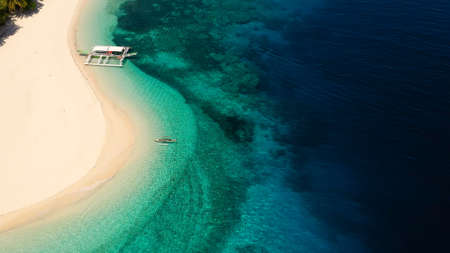Seascape with a beautiful tropical island, aerial view. Beautiful white sand beach. Mahaba Island, Philippines. Blue sea with turquoise lagoons. Summer and travel vacation concept.の写真素材
