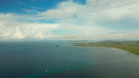 Tropical island with palm trees and beach against the sky and clouds, aerial view. Philippines, Siargao. Summer and travel vacation conceptの写真素材