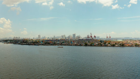 Sea port on the background of the city of Manila with skyscrapers and modern buildings. Modern buildings in the city center.の写真素材