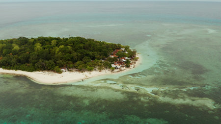 Beautiful beach on tropical island surrounded by coral reef, top view. Mantigue island. Small island...
