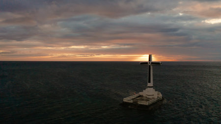 Catholic cross in sunken cemetery in the sea at sunset, aerial drone. colorful sky during the...
