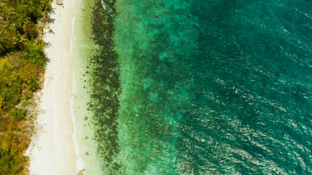 White sandy beach and azure water of the lagoon,copy space for text, top view. Ocean with waves and tropical beach. Summer and travel vacation conceptの写真素材
