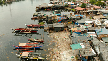 Slums in Manila on the bank of a river polluted with garbage, aerial view.の写真素材