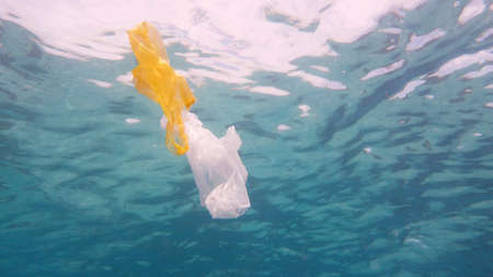 Plastic bag in blue ocean water. Plastic pollution in ocean environmental problem. Ecological problem, Environmental Pollution.の写真素材