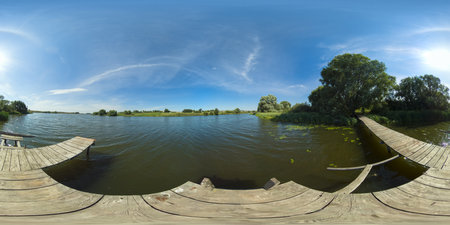 Summer landscape: lake with pier on the background of blue sky and clouds. 360VR.