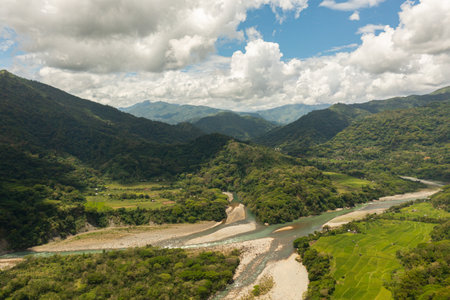 Aerial drone of mountain slopes with rainforest and agricultural land of farmers.の写真素材