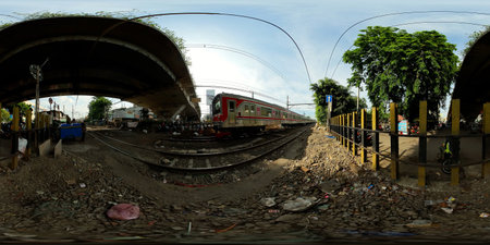 Indonesia - Sep 28, 2022: Train in Jakarta and motorbike traffic at the railway crossroads. Street...