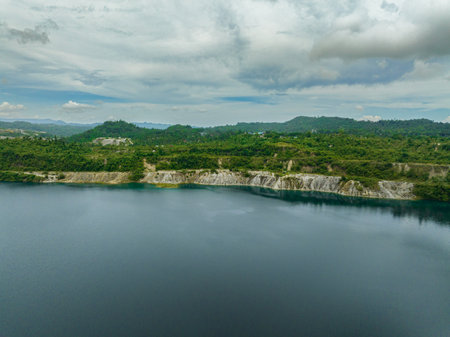 Aerial drone of mining quarry with flooded bottom. Lake with blue water near sand pit. Sipalay, Negros, Philippines.の写真素材