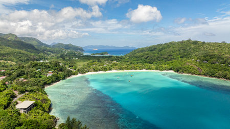Beach cove embraced by lush tropical vegetation and mountains. Port Launay Beach. Seychelles.の写真素材