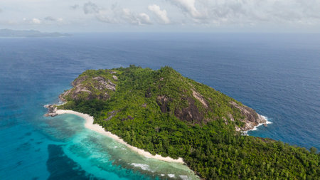 Idyllic island with a clear sandy beach, turquoise waves and green trees. Seychelles.の写真素材
