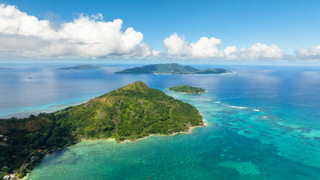 Aerial view of island with dense green vegetation sits amidst the turquoise waters. Praslin, Seychelles.の写真素材
