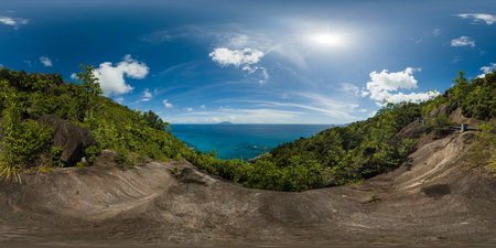 A view from a mountain peak, showcasing lush green forests and vibrant blue ocean waters under a...