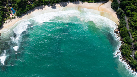 Turquoise waters kiss the beachs sandy shore, surrounded by vibrant flora. Seychelles, Mahe. Anse...
