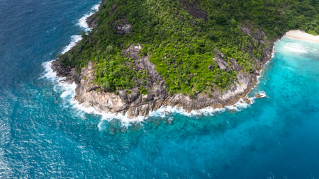 Tropical coastline featuring vibrant greenery, rugged rocks Seychelles, Mahe.