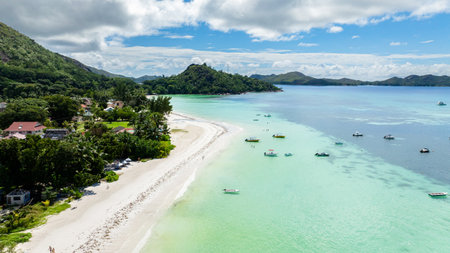 Tropical beach with clear, blue water and lush green trees. Praslin, Seychelles.