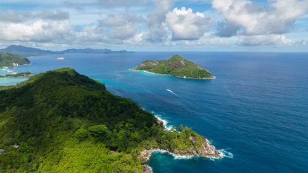 Expansive view of the ocean with two islands surrounded by clear blue waters and clouds. Seychelles, Mahe.の写真素材