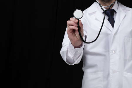 Doctor with stethoscope stay on black backgroundの写真素材