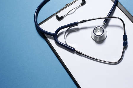 Stethoscope and tablet for recording patients in clinic on blue backgroundの写真素材