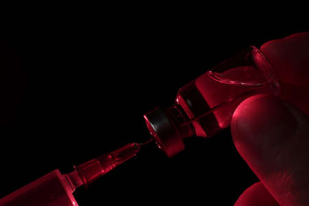 Vaccine vial and syringe on black backgroundの写真素材
