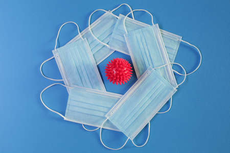 Viral Coronavirus Bacteria And Protective Medical Disposable Masks On A Blue Background. Concept Of Air Pollution, Pneumonia Outbreaks, Epidemicsの写真素材