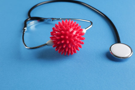 Black medical stethoscope and red imitation molecule on blue backgroundの写真素材