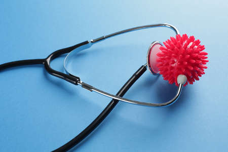 Black medical stethoscope and red imitation molecule on blue backgroundの写真素材