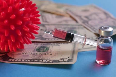 Medical Syringe vials with vaccine on the background of American dollars. Viral Bacteria.の写真素材