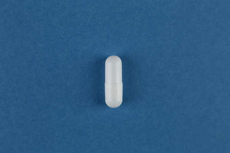 One medical pill on a blue background. Close-upの写真素材