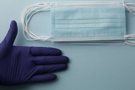 Pair of latex gloves and surgical ear-loop mask on blue background. Protection conceptの写真素材