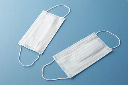 Respiratory medical masks on blue background. Protective medical mask. Coronavirus protection concept.の写真素材
