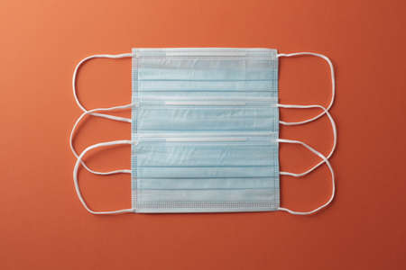 Respiratory masks on orange background. Coronavirus protection concept.