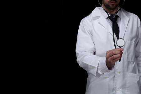 Doctor with medical stethoscope on black backgroundの写真素材