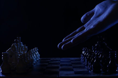 Hand points to chess pieces on the boardの写真素材