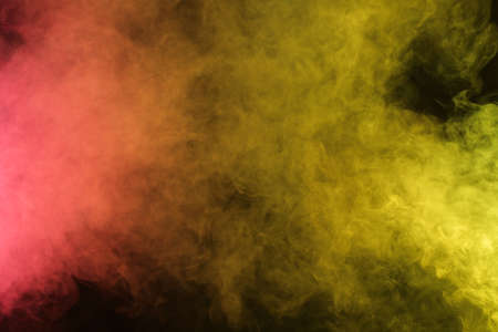Artificial smoke in red-yellow light on black background