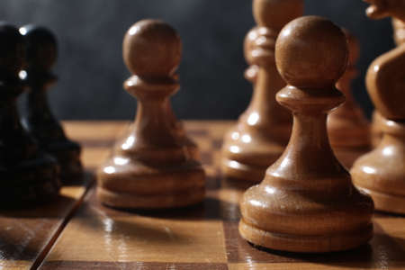 Wooden chess is a board game. Chess pieces on a dark background