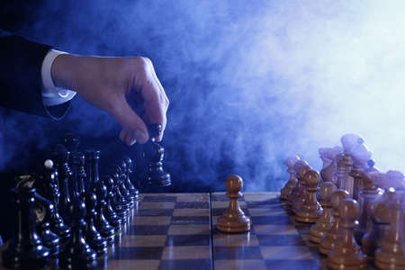 Hand of businessman moving chess pieces in a success game competition. Strategy, management or leadership conceptの写真素材