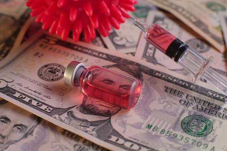 Syringe vials with vaccine on the background of American dollars.