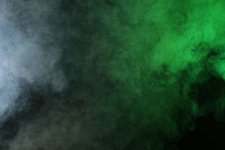 Artificial smoke in red-green light on black backgroundの写真素材