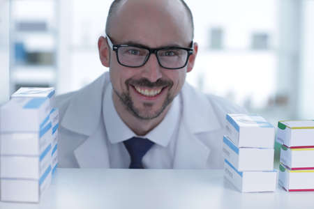 Pharmacist is working. Man wearing special medical uniform. A man looks through the patches in pharmacy.の写真素材